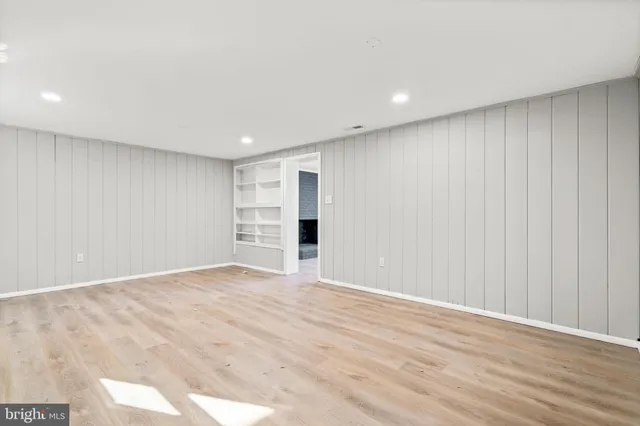 an empty room with wooden floor and window