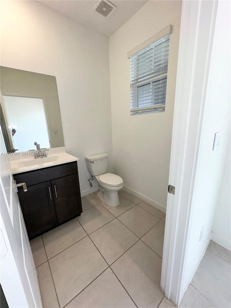 1848 Southeast 7th Street, Unit 1848 Homestead, FL 33033 - Photo 20 of 29 a bathroom with a granite countertop toilet and a sink
