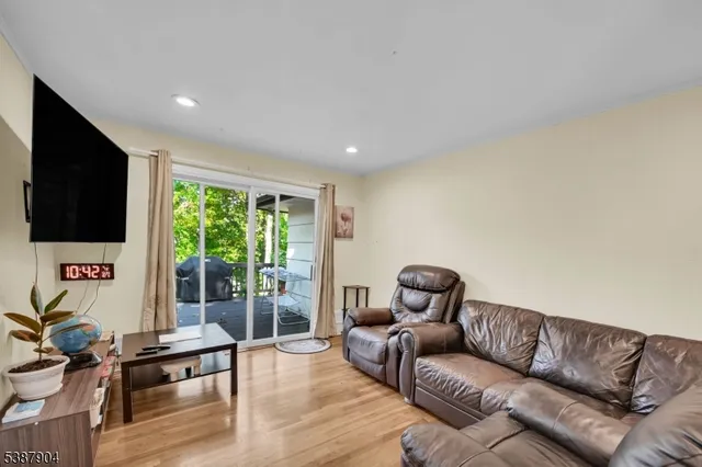a living room with furniture ceiling fan and a flat screen tv
