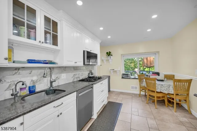 a kitchen with a sink and chairs