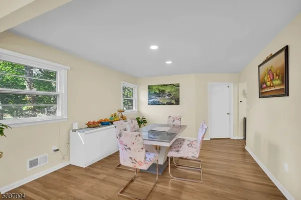a dining room with wooden floor and a window