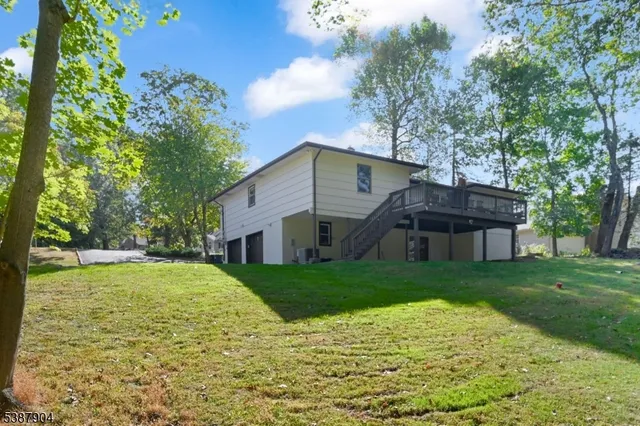 a view of a big house with a big yard and large trees