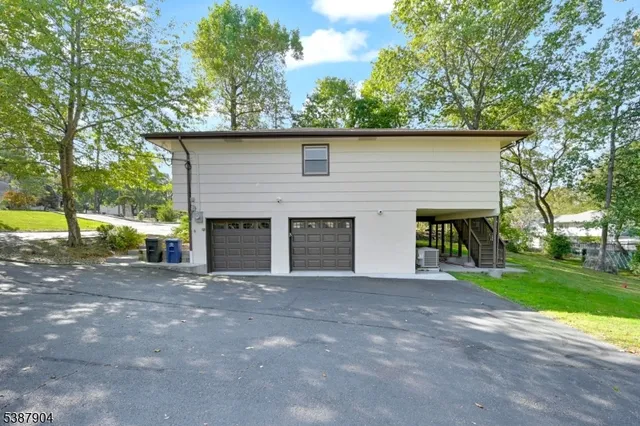 a front view of a house with a garden and trees