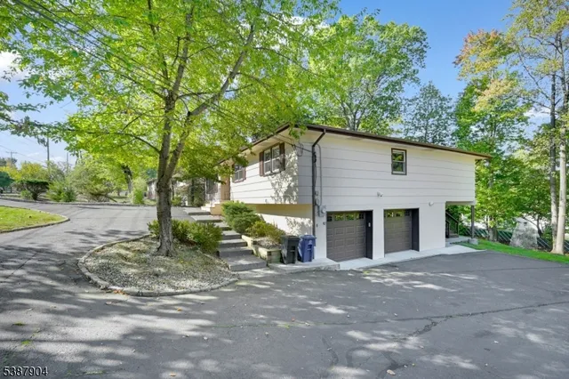 a view of a house with a yard and large tree