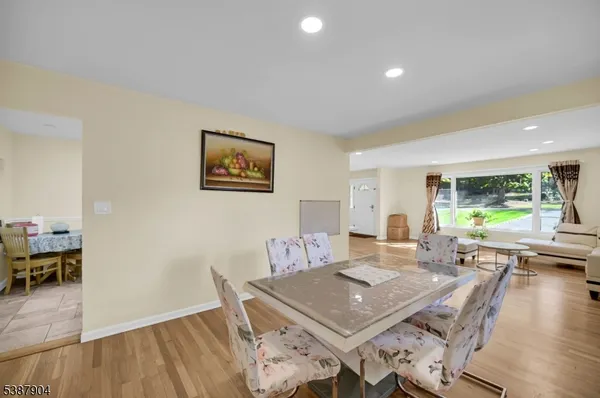 a living room with furniture a wooden floor and next to a window