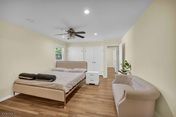 a spacious bedroom with a bed a couch and a ceiling fan