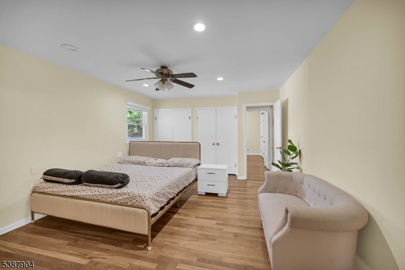 30 County Rte 635 Livingston, NJ 07039 - Photo 10 of 40 a spacious bedroom with a bed a couch and a ceiling fan