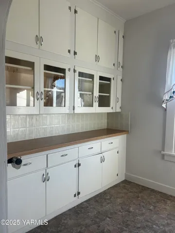 a view of kitchen with granite countertop white cabinets
