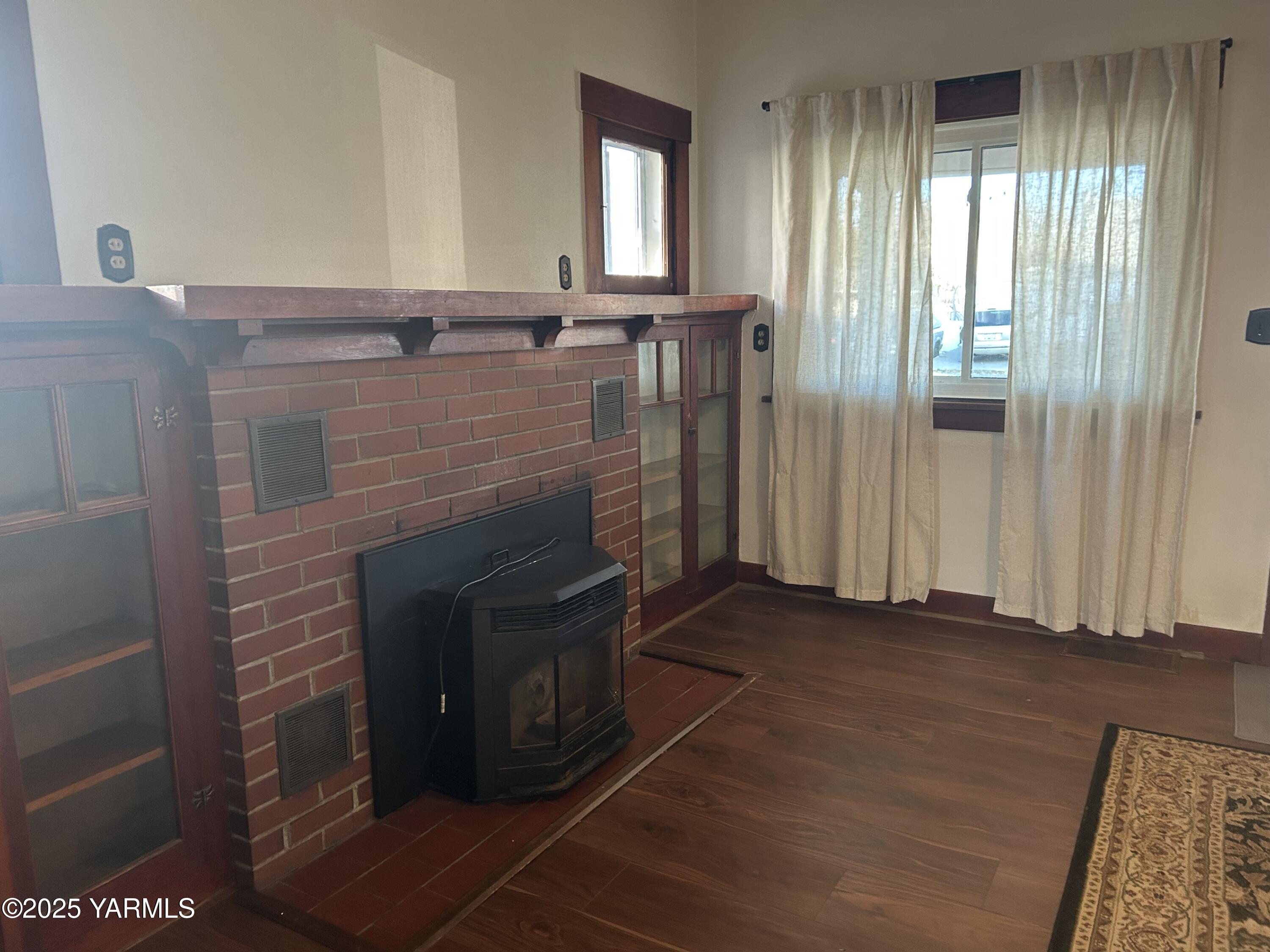 1110 South 8th Avenue Yakima, WA 98902 - Photo 3 of 25 a view of an empty room with wooden floor and a fireplace