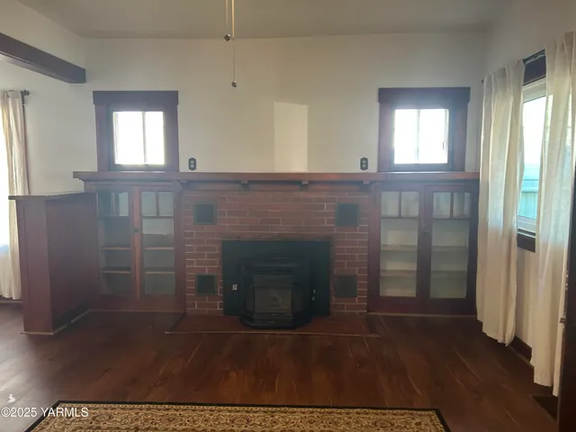 a view of a livingroom with wooden floor and a fireplace