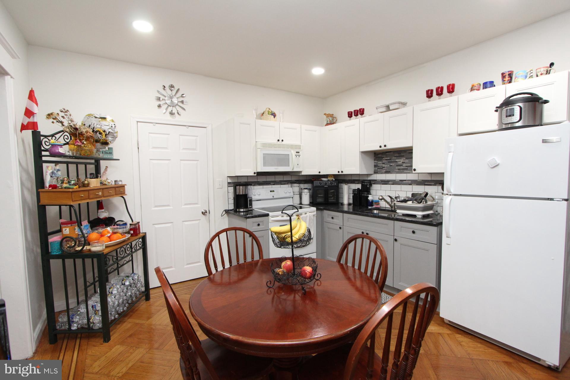 2311 Rhawn Street Philadelphia, PA 19152 - Photo 23 of 34 a kitchen with stainless steel appliances granite countertop a dining table chairs and a refrigerator