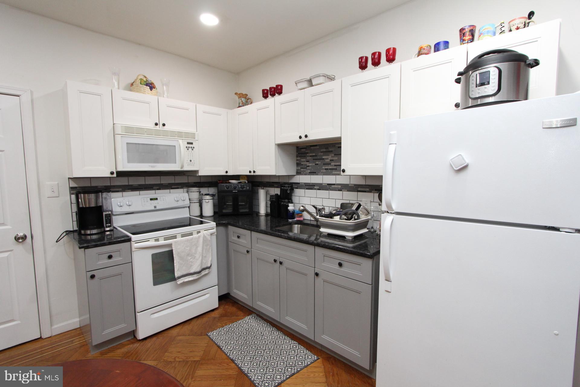 2311 Rhawn Street Philadelphia, PA 19152 - Photo 24 of 34 a white kitchen with cabinets and stainless steel appliances