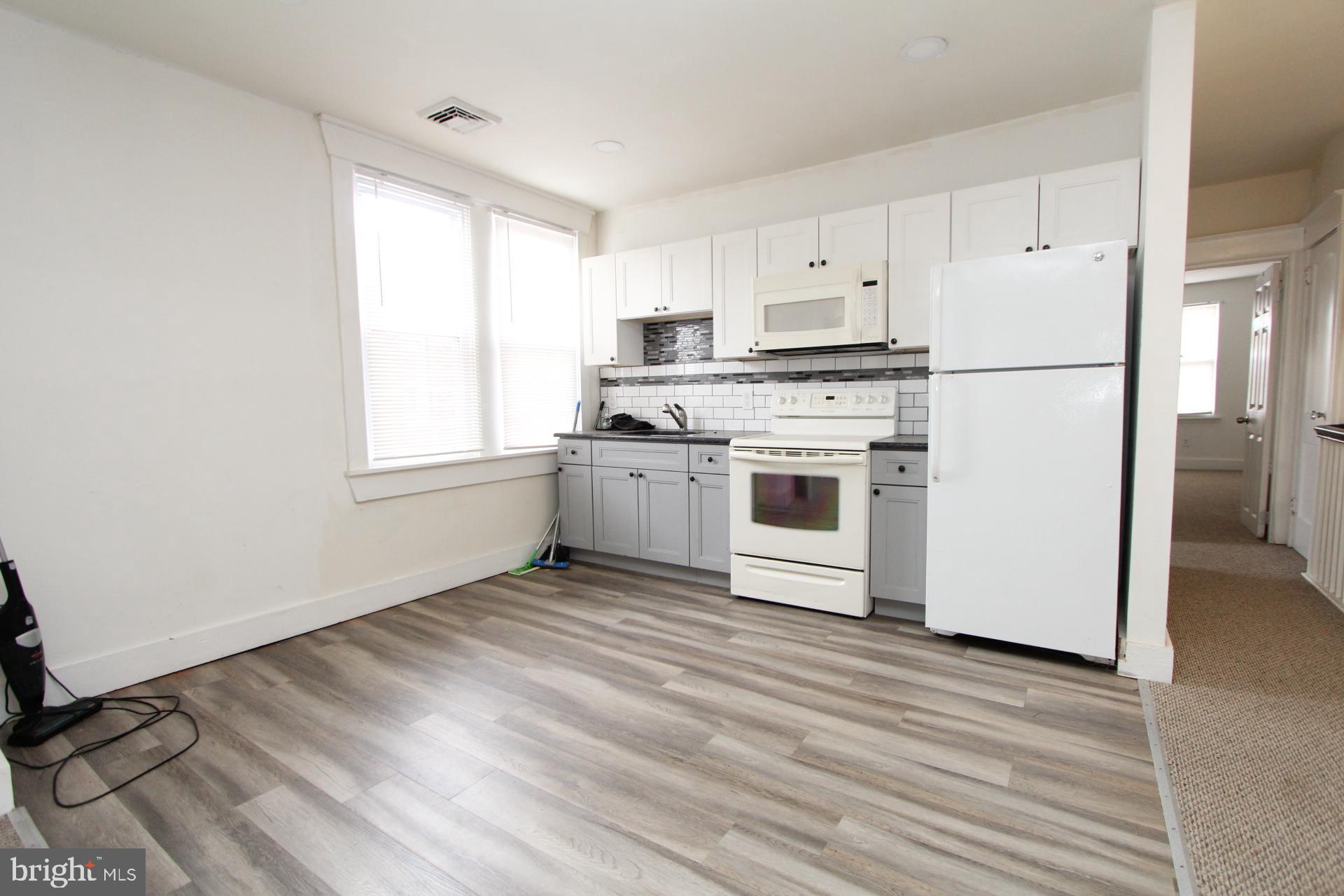 2311 Rhawn Street Philadelphia, PA 19152 - Photo 9 of 34 a kitchen with a refrigerator stove and white cabinets
