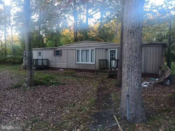 a view of a house with backyard and trees