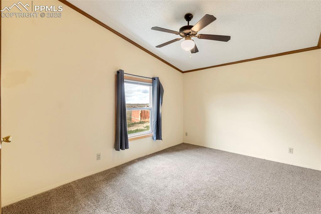 13335 Gymkhana Road Peyton, CO 80831 - Photo 32 of 38 Carpeted room featuring a single window, a ceiling fan with integrated lighting, and vaulted ceilings
