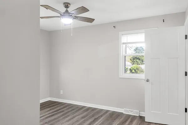 a view of a hallway with wooden floor and workspace