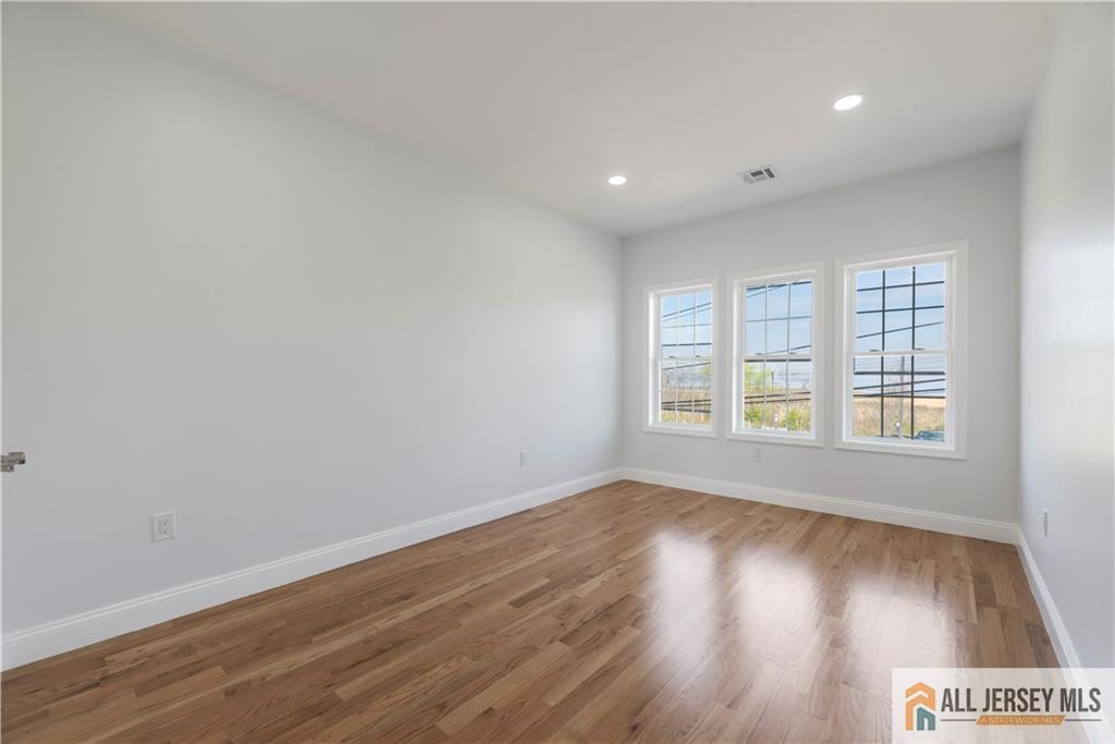 452 Raritan Boulevard Old Bridge, NJ 07735 - Photo 14 of 29 an empty room with wooden floor and windows