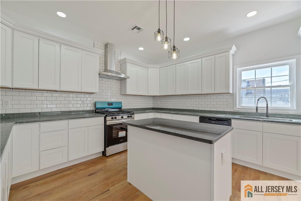 452 Raritan Boulevard Old Bridge, NJ 07735 - Photo 6 of 29 a kitchen with stainless steel appliances granite countertop a sink stove and white cabinets