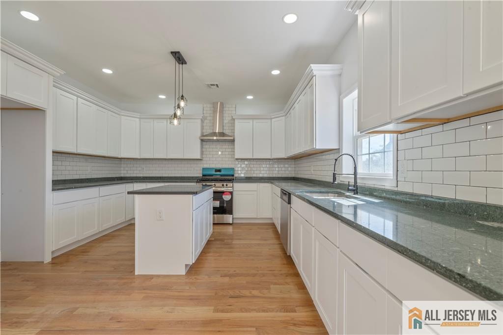 452 Raritan Boulevard Old Bridge, NJ 07735 - Photo 7 of 29 a kitchen with a sink window and white cabinets
