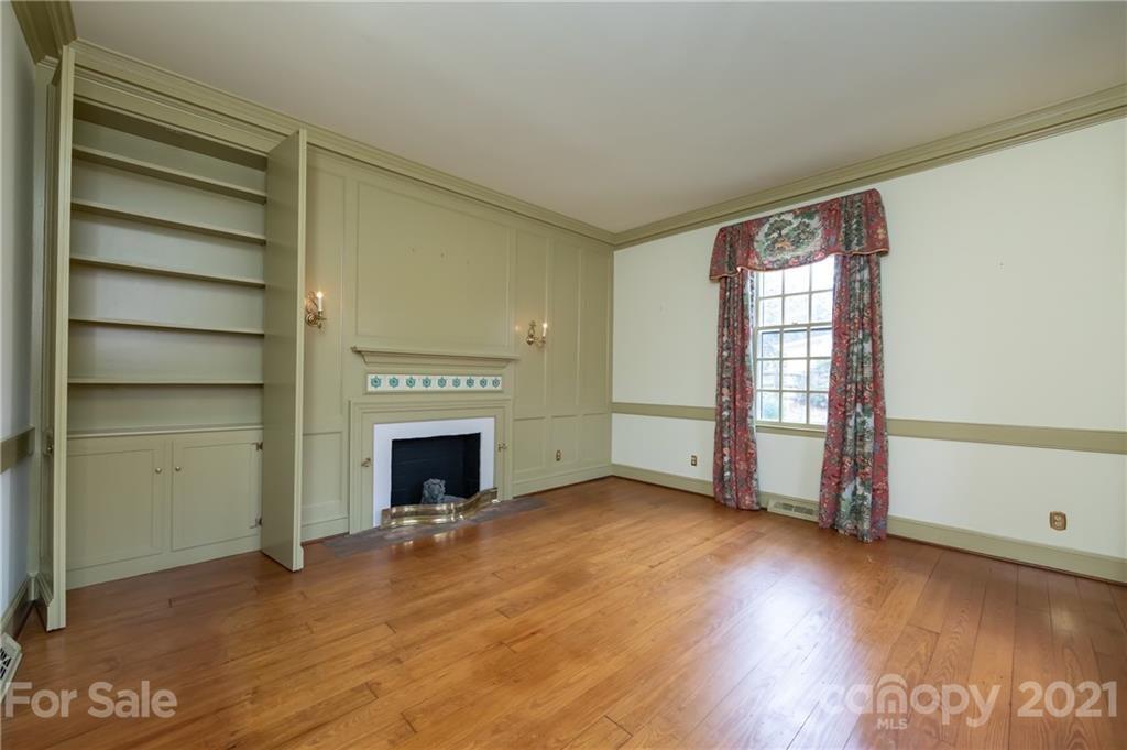 3229 Colony Road Charlotte, NC 28211 - Photo 6 of 44 an empty room with wooden floor fireplace and windows