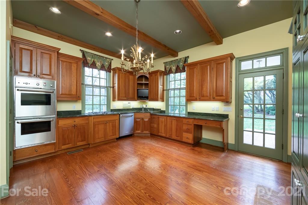 3229 Colony Road Charlotte, NC 28211 - Photo 8 of 44 a large kitchen with stainless steel appliances wooden floors and large windows