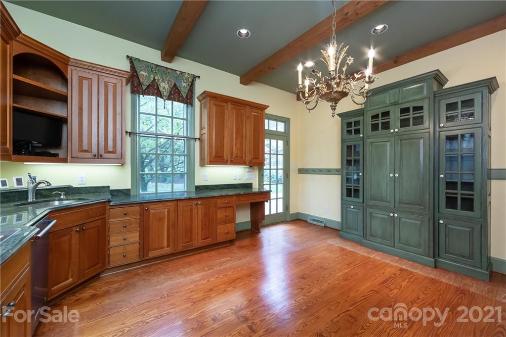 3229 Colony Road Charlotte, NC 28211 - Photo 9 of 44 a large kitchen with stainless steel appliances granite countertop a refrigerator a sink dishwasher a dining table and chairs with wooden floor