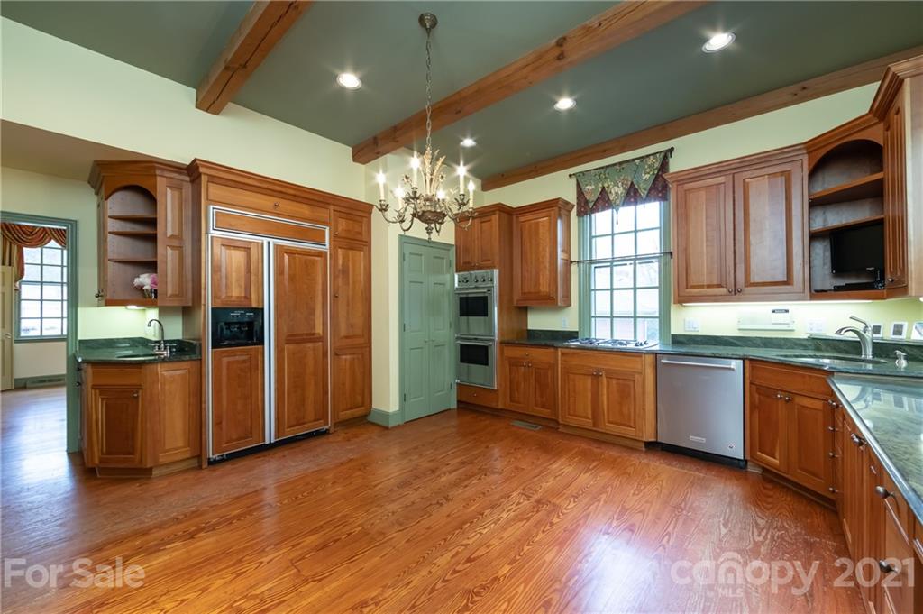 3229 Colony Road Charlotte, NC 28211 - Photo 10 of 44 a large kitchen with stainless steel appliances granite countertop a refrigerator a sink dishwasher a stove and a dining table with wooden floor