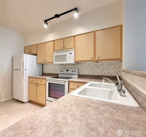 a kitchen with a refrigerator sink and white cabinets