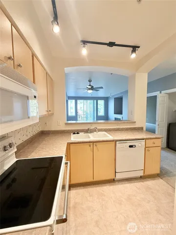 a large white kitchen with a stove a sink and a refrigerator