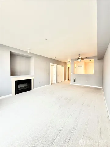 a view of an empty room with a fireplace and a window