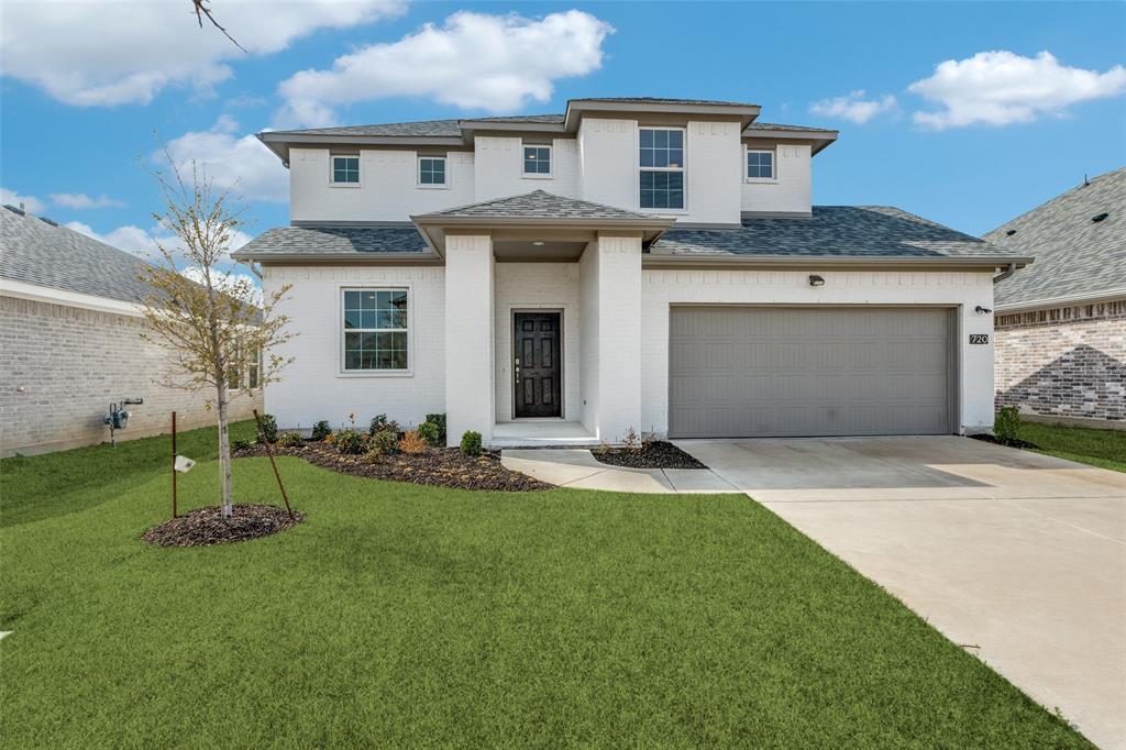 Prairie-style house with roof with shingles, a front yard, brick siding, and concrete driveway