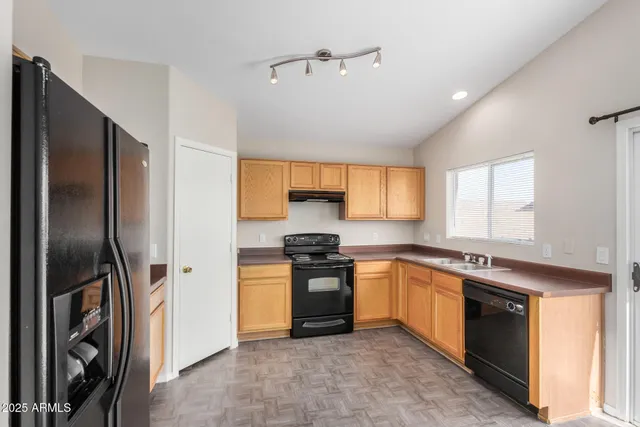 an empty room with chandelier fan and windows