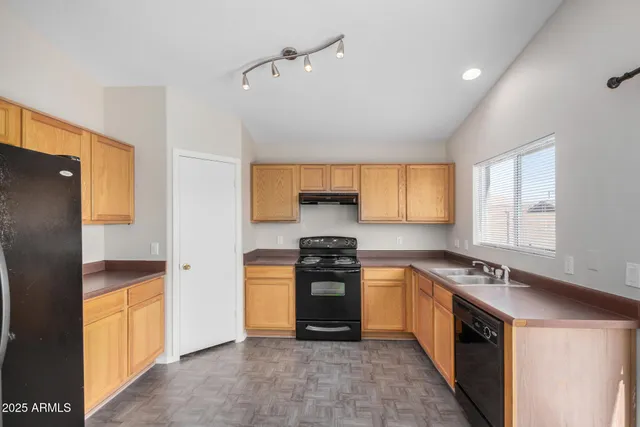 an empty room with a fan & a window