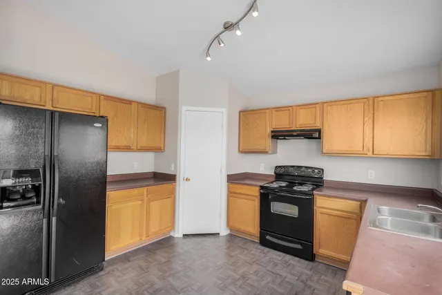a kitchen with stainless steel appliances granite countertop a stove a sink and a refrigerator