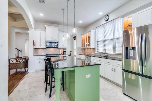 a kitchen with kitchen island a large counter top space appliances and cabinets