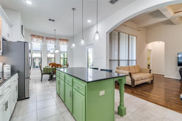 a kitchen with kitchen island a large counter top space a sink stainless steel appliances and cabinets