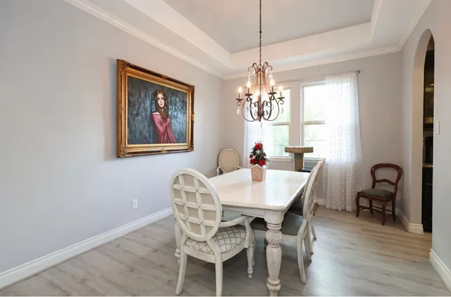 a view of a dining room with furniture a chandelier and wooden floor