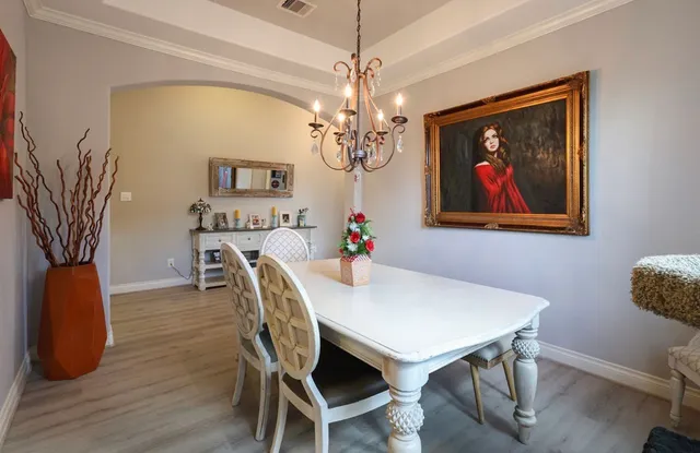 a view of a dining room with furniture and a chandelier