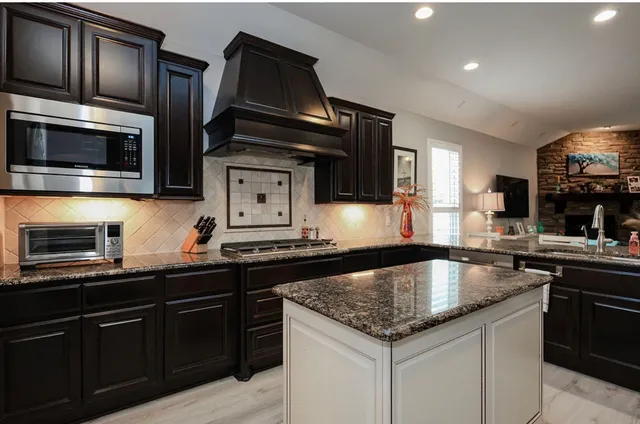 a kitchen with stainless steel appliances granite countertop a sink and stove top oven