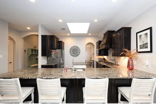a bathroom with granite countertop a sink and a mirror