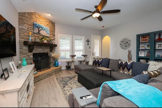 a living room with furniture a fireplace and a flat screen tv