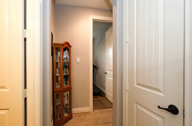 a view of a hallway with wooden floor and closet