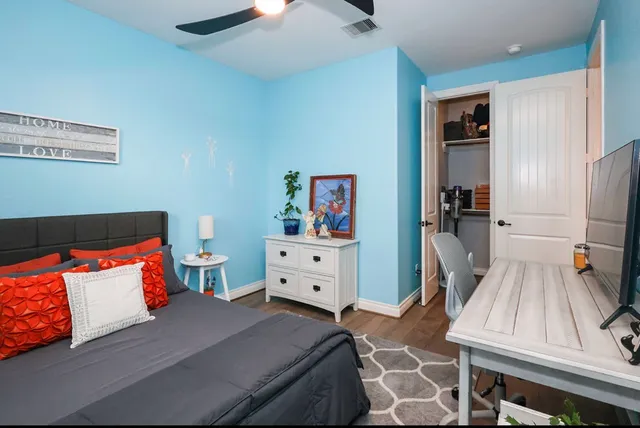 a bedroom with a bed and wooden floor