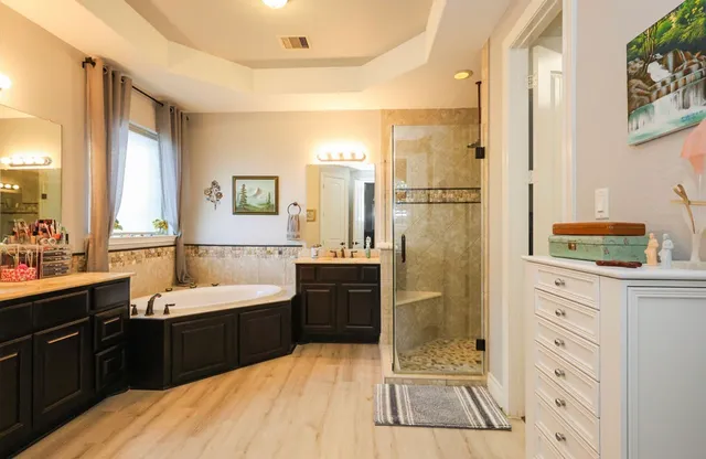 a spacious bathroom with a tub sink shower and mirror