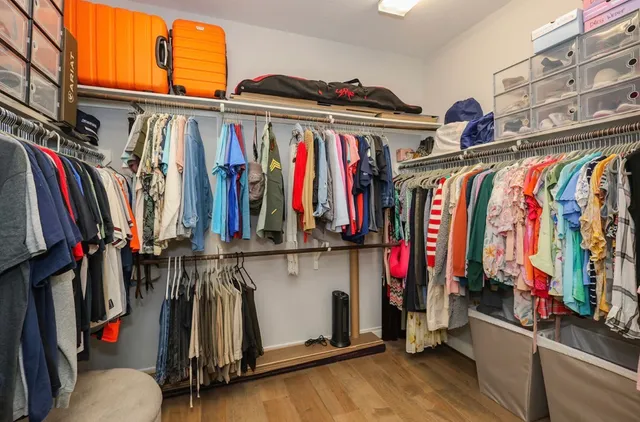 a view of walk in closet with clothes and shoes