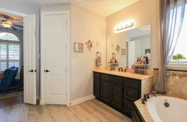 a bathroom with a tub sink and mirror
