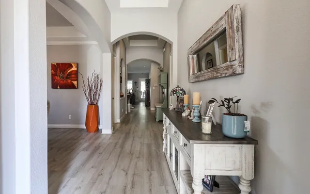a hallway with a view of living room with wooden floor