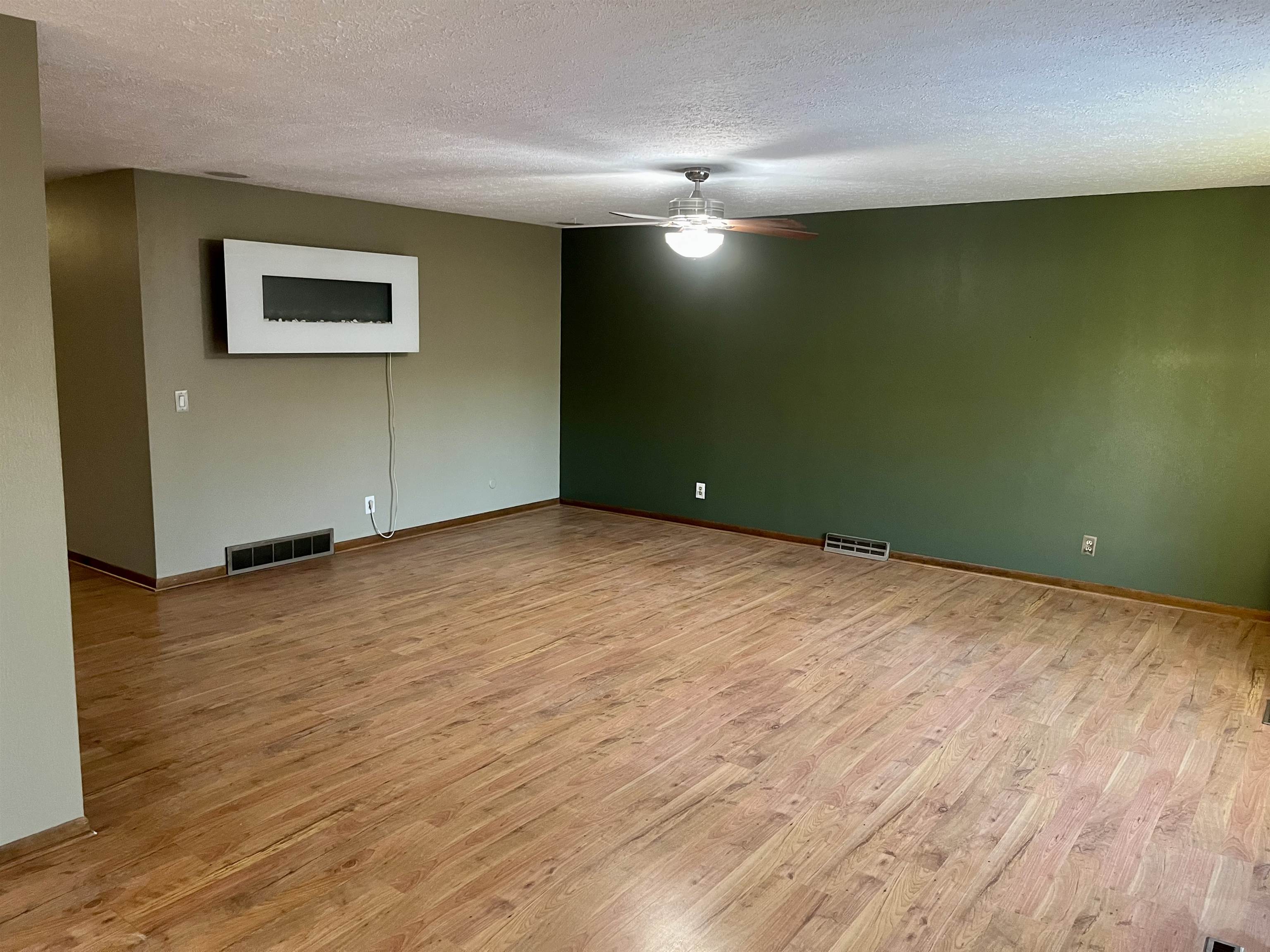 4575 Sunderman Road Rockford, IL 61114 - Photo 3 of 16 an empty room with wooden floor and windows