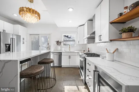 a kitchen with a sink dishwasher a stove a dining table and chairs