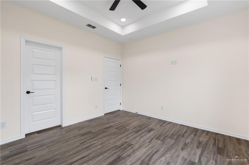 18054 Spruce Street Combes, TX 78552 - Photo 18 of 25 Spacious room featuring wood-finish flooring and a tray ceiling with recessed lighting